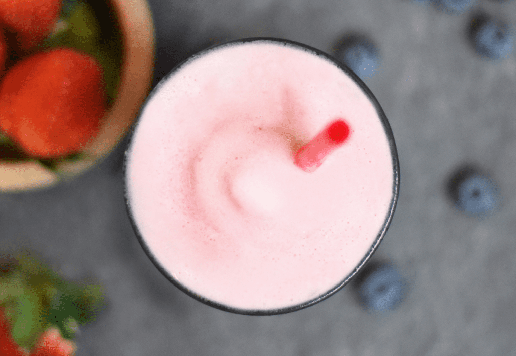 A pink smoothie with berries.