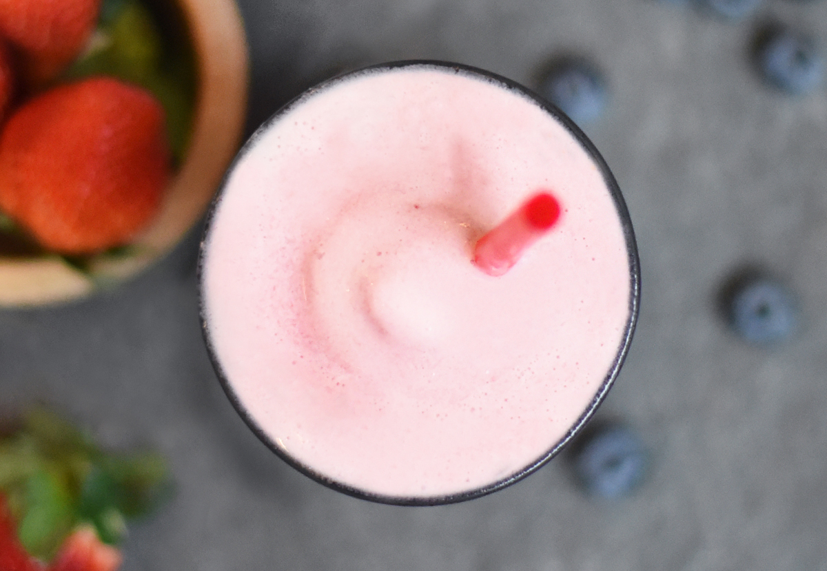 A pink smoothie with berries.