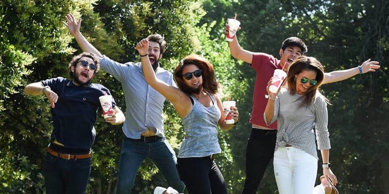 A group of people are posing for a picture in a park.