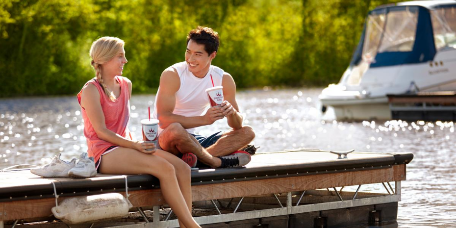 A couple enjoying a cup of coffee on a dock.