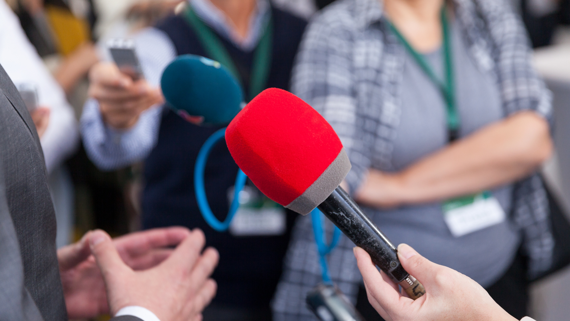 A group of people holding microphones at a public relations event for a smoothie franchise.