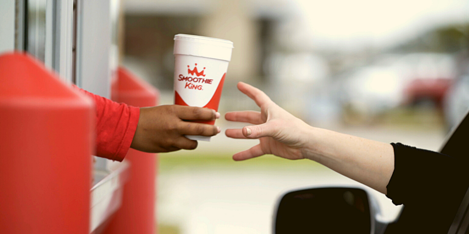 A person delivering exceptional guest service by handing someone a cup of coffee.