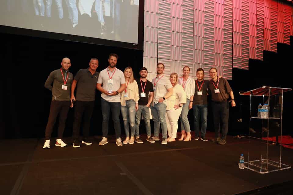 A group of Smoothie King employees standing on stage during a conference.