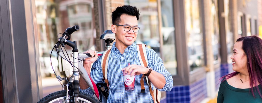 A couple engaging with your brand mission by showcasing a bicycle outside a store.