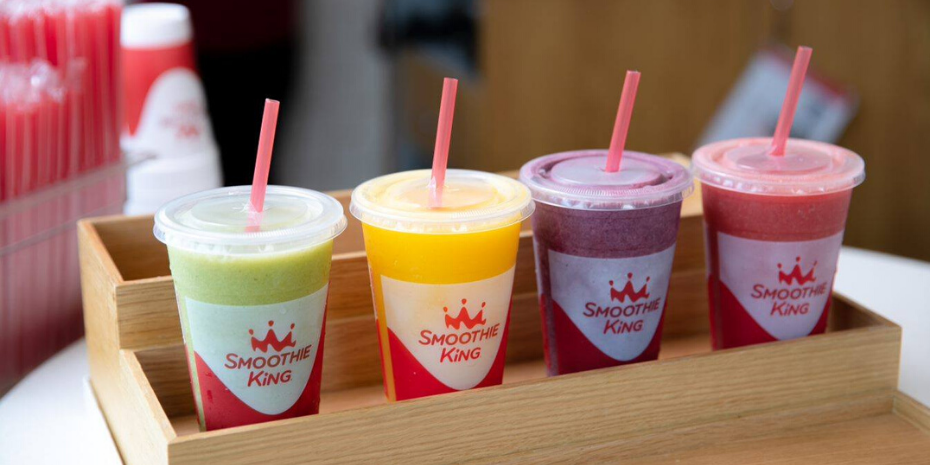 Four smoothies on wooden tray.