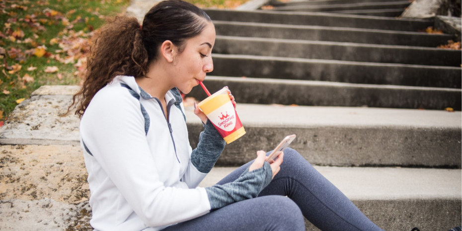 Enjoying a revitalizing fruit smoothie from Smoothie King franchise.