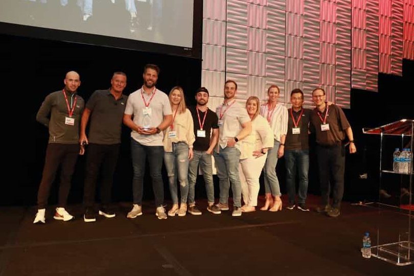 A group of Smoothie King employees standing on stage during a conference.