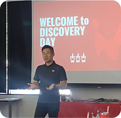 Wan kim making a speech at a smoothie king franchisee welcome to discovery day