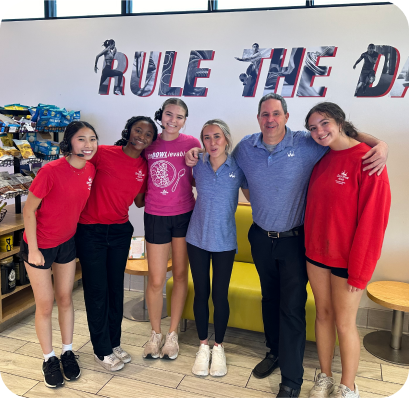 group of people posing for picture inside of smoothie king store