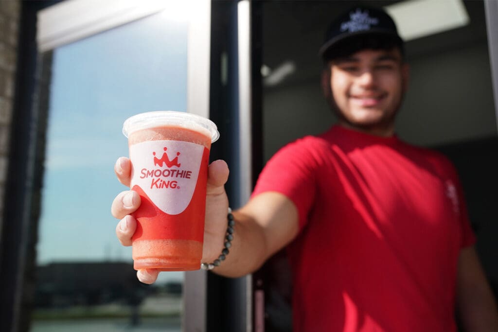 Smoothie King Employe in the drive-thru lane handing out a smoothie
