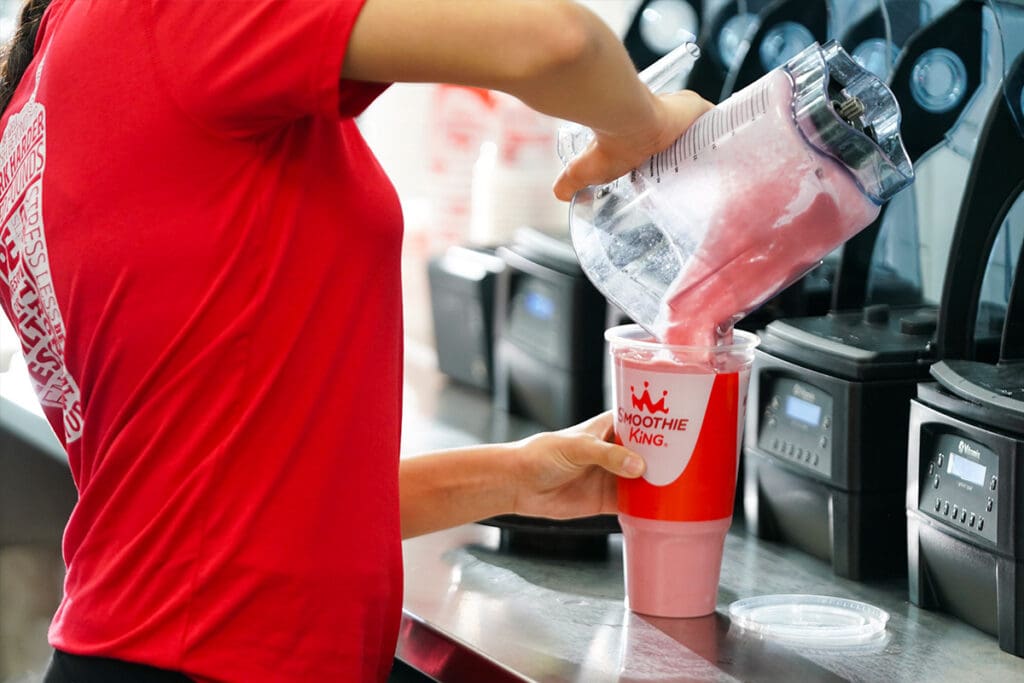 Smoothie King Employee serving a smoothie
